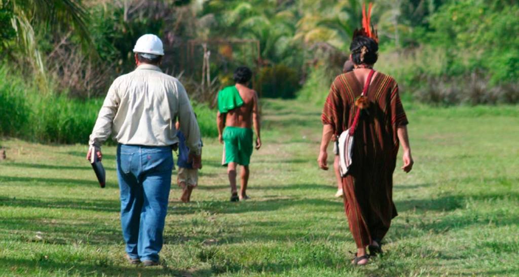 Un empleado de Repsol camina junto a un indigena de la comunidad 